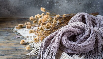 A boho background with knitted scarf, dried flowers, and copyspace 