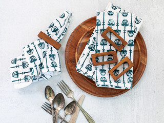 Table linens and napkins with napkin holders plates cutlery top view tablescape