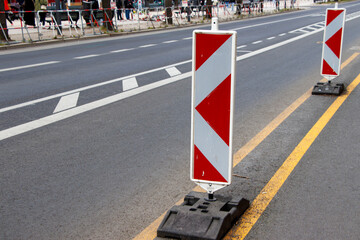Traffic cones placed on a road during a construction project, signaling detours. Unoccupied streets under soft lighting create a sense of calm amidst urban work.
