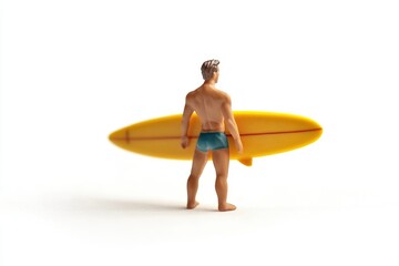 A miniature surfer, seen from behind, stands proudly holding his yellow surfboard.
