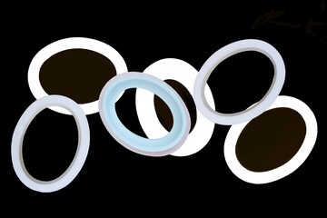 Photographic image showing oval shape picture frames. Six isolated ovals for framing design show empty centers. They overlap with central one in  blue & gold.