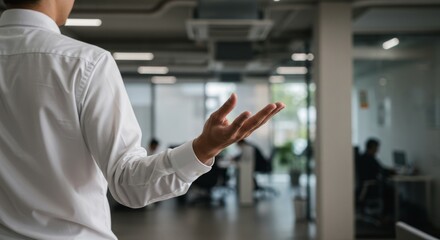 Business Presentation Gesture - Rear view of a person in a white shirt gesturing during a presentation in a modern office