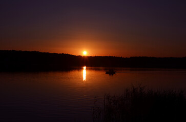 peaceful landscape with a boat on the lake at dusk