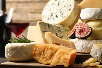 Different types of cheese, figs and rosemary on table, closeup
