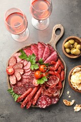 Different smoked sausages slices served on grey table, flat lay