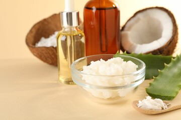 Hair treatment. Cosmetic products, coconut, butter shavings and aloe leaves on beige background, closeup