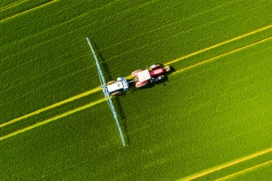 Pesticide aplication. A tractor with chemical sprayer working on a field.