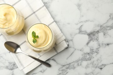 Tasty vanilla pudding with mint served on white marble table, flat lay. Space for text