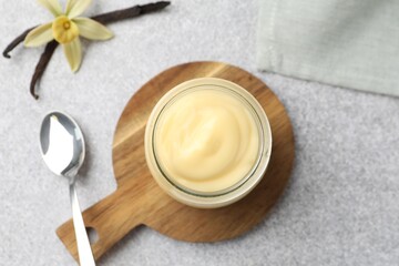 Tasty vanilla pudding, pods and flower on grey table, flat lay