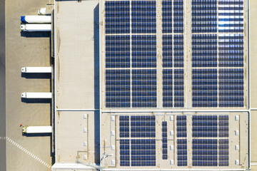 Industry with low carbon footprint. Industrial warehouses with solar panels on the roof. Technology park and factories from above