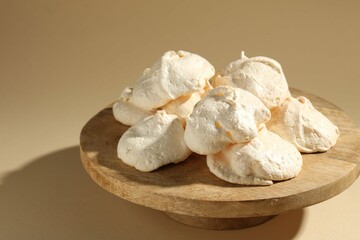 Delicious homemade meringue cookies on beige background, closeup