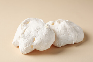 Delicious homemade meringue cookies on beige background, closeup