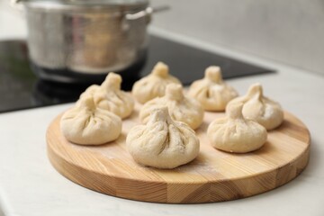 Many uncooked khinkali on countertop indoors, closeup