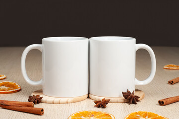 Two Blank 11oz white mugs on on the table. Mugs with warm spices like cinnamon, star anise, dried orange. Mug mockup