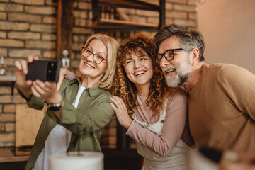 Smiling mum, dad and daughter posing for self portrait on cell