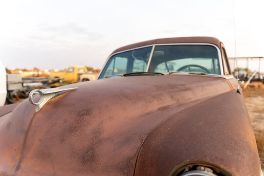 Weathered Brown Car with Cloudy Sky