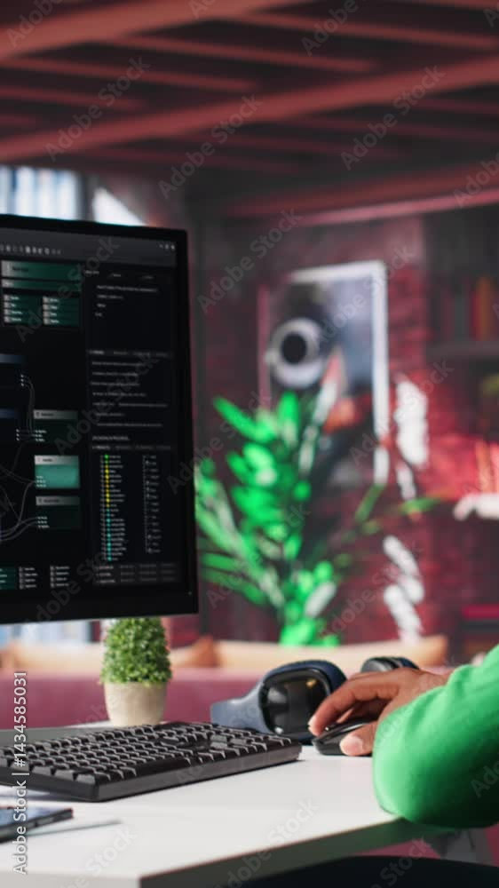 Poster Vertical Video African american man looks at notes on terminal window for visual programming, typing code on software at his home office. Coding application UI used by engineer writing and testing