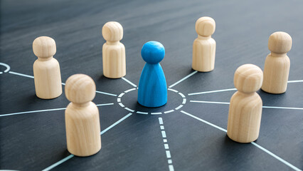 Leadership Network: The blue figure stands at the center, surrounded by wooden figures, symbolizing the power of connection and the importance of leadership in fostering collaboration and growth.