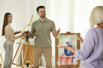 Artist and his students having painting class in studio