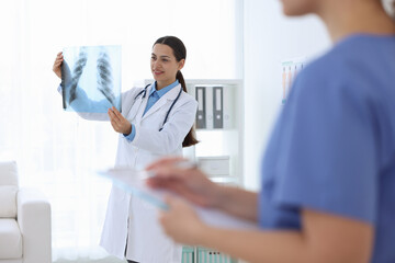Doctor and nurse examining MRI scan in hospital, selective focus