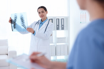 Doctor and nurse examining MRI scan in hospital, selective focus