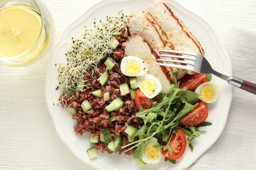Delicious salad with brown rice and drink on white wooden table, top view