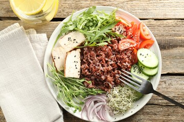 Delicious salad with brown rice and drink on wooden table, flat lay