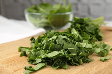 Board with cut fresh sorrel on table, closeup