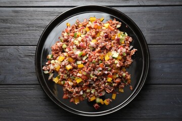 Tasty salad with brown rice on black wooden table, top view