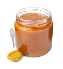 Tasty curry sauce in glass jar and spoon with powder isolated on white