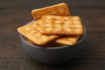 Tasty salty crackers on wooden table, closeup