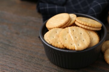 Tasty salty crackers on wooden table, closeup. Space for text