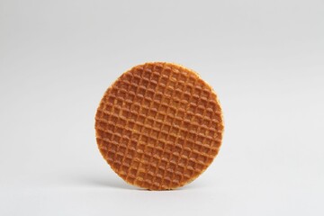 One tasty round waffle on white background