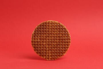 One tasty round waffle on red background