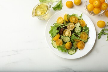 Fresh salad with yellow tomatoes on white table, flat lay. Space for text