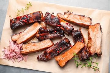 Delicious pork ribs, thyme and onion on grey table, top view