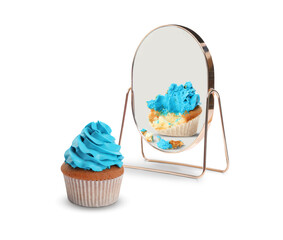Whole cupcake reflecting in mirror as bitten, white background. Opposite, contrast, difference
