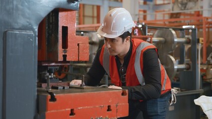Engineer or operator wearing a safety suit working bending metal sheet by sheet press bending...
