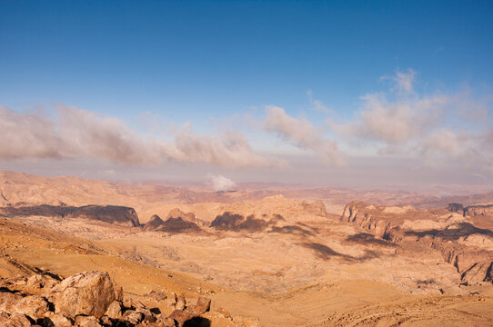 A desert landscape with a cloudy sky in the background