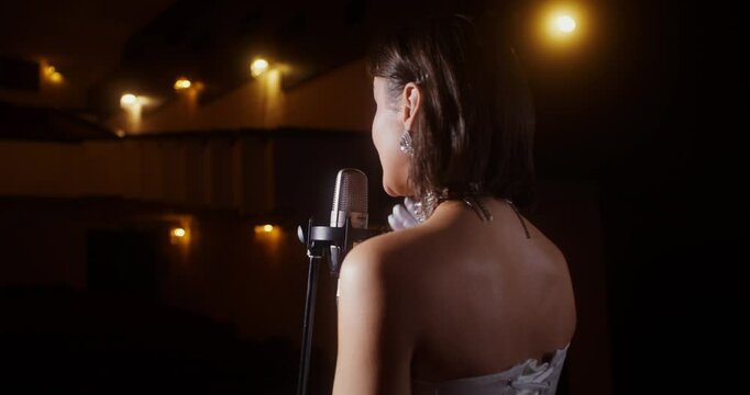 A singer on the stage. Solo performance by lamplight