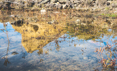 Mountain hill reflection in the puddle lake water