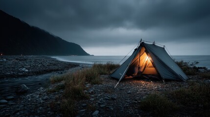 Setting up a glowing tent by the shore coastal landscape photography evening serene atmosphere