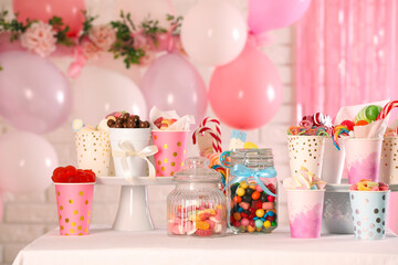 Candy bar. Many different sweets on table in festive decorated room