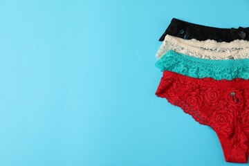 Women's underwear. Beautiful panties on light blue background, flat lay. Space for text