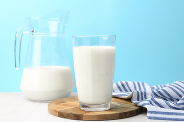 Fresh milk on white table against light blue background
