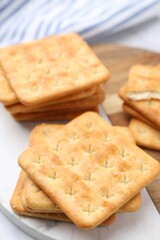 Tasty salty crackers on white table, closeup