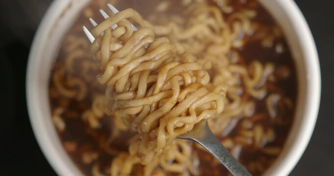 Hot instant noodles soup, Ramen soup on fork. 
