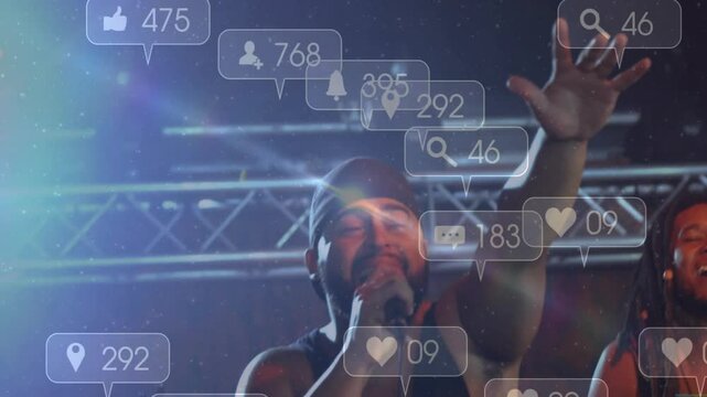 Lead singer gripping microphone raising arm on tech-focused stage, with floating social media icons
