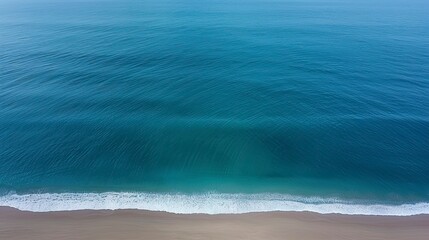 Obraz premium High angle view of ocean waves gently crashing on a beach