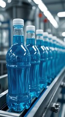 Plastic water bottles lined up on an automated production line inside a modern factory, highlighting concepts of mass production, beverage industry, packaging, and manufacturing efficiency.
